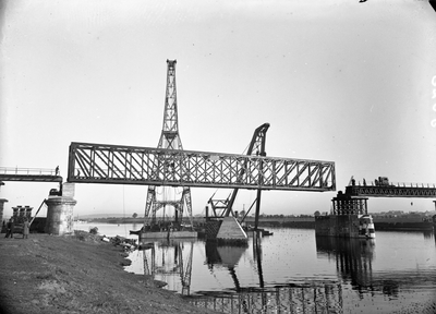 152681 Afbeelding van het plaatsen van de middenoverspanning van de spoorbrug over de Maas te Gennep, tijdens het ...